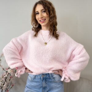 Jasno różowy oversize'owy sweter z falbanką na rękawie